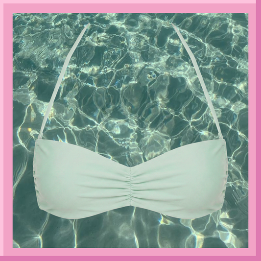 White bikini top with straps over clear pool water